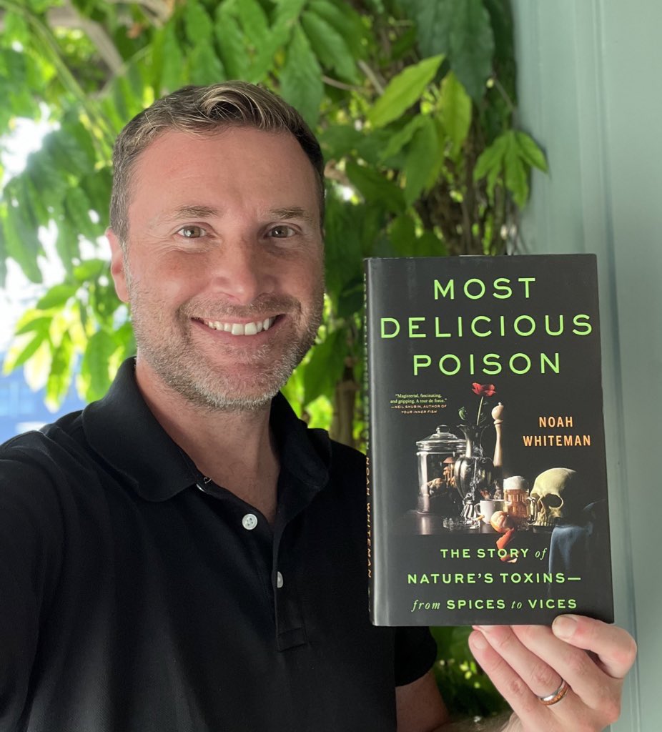 Professor Noah Whiteman holding a copy of his book, Most Delicious Poison. 